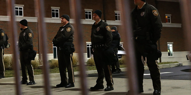 FERGUSON, MO - NOVEMBER 24: St. Louis County police officers stand guard in front of the Ferguson police department on November 24, 2014 in Ferguson, Missouri. A St. Louis County grand jury has reached a decision on whether or not to charge Ferguson police Officer Darren Wilson in the shooting of Michael Brown that sparked riots in Ferguson, Missouri in August.   Justin Sullivan/Getty Images/AFP== FOR NEWSPAPERS, INTERNET, TELCOS & TELEVISION USE ONLY ==