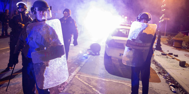 FERGUSON, MO - NOVEMBER 25: Police stand guard at City Hall during protests on November 25, 2014 in Ferguson, Missouri. Over 2,000 Missouri national guardsmen are being deployed a day after demonstrators caused extensive damage in Ferguson and surrounding areas following a St. Louis County grand jury decision to not indict Ferguson police officer Darren Wilson in the shooting of Michael Brown.   Aaron P. Bernstein/Getty Images/AFP== FOR NEWSPAPERS, INTERNET, TELCOS & TELEVISION USE ONLY ==