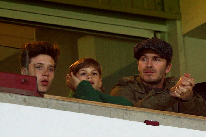 LONDON, ENGLAND - MARCH 22:  (R-L) David Beckham and his sons Romeo Beckham and Brooklyn Beckham watch the action during the Barclays Premier League match between West Ham United and Manchester United at Boleyn Ground on March 22, 2014 in London, England.  (Photo by Paul Gilham/Getty Images)