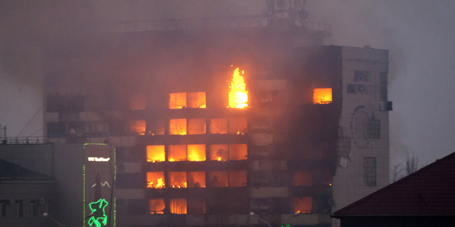 The media building burns as militants attack in central Grozny on December 4, 2014. Several police died in clashes with militants who attacked a traffic post in the Chechen capital Grozny and then stormed a building housing local media, Russian officials said on Thursday. AFP PHOTO/ELENA FITKULINA