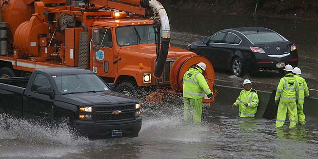 SOUTH SAN FRANCISCO, CA - DECEMBER 11: CalTrans workers attempt to clear a drain at a flooded section of highway 101 on December 11, 2014 in South San Francisco, California. The San Francisco Bay Area is being hit with a severe storm that is bringing high winds and heavy rain that have toppled trees and caused local flooding.   Justin Sullivan/Getty Images/AFP== FOR NEWSPAPERS, INTERNET, TELCOS & TELEVISION USE ONLY ==