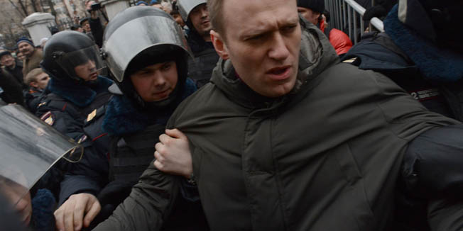 Police officers detain protest leader Alexei Navalny outside Zamoskvoretsky district court in Moscow, on February 24, 2014, during a protest against the trial of eight people accused of instigating mass riots after an opposition rally on Moscow's on Bolotnaya square turned violent on the eve of Vladimir Putin's inauguration as president in 2012. A Russian court resumed today the sentencing of the eight anti-Putin protesters found guilty of mass riots as police detained dozens of people protesting against the trial. AFP PHOTO / VASILY MAXIMOV