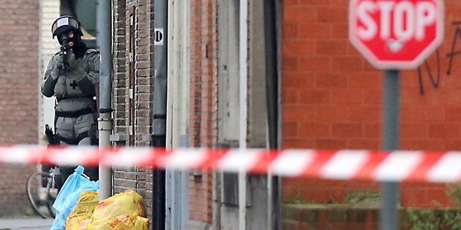A Belgian policeman takes position near the Pilorijnstraat after four armed men invaded an apartment near Gent on December 15, 2014. Four armed men have taken a hostage in the apartment, but no terror link is suspected, prosecutors said. AFP PHOTO / BELGA / NICOLAS MAETERLINCK== BELGIUM OUT ==