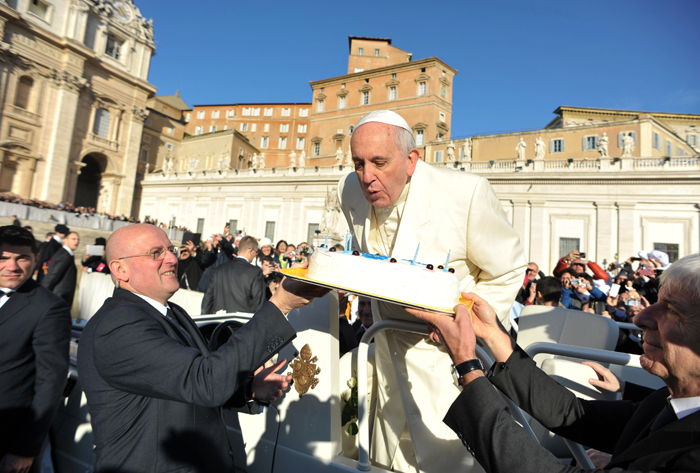 This handout picture released on December 17, 2014 by the Vatican press office shows Pope Francis blowing the candles of a birthday cake to celebrate his 78th birthday during a general audience at the Vatican.   AFP PHOTO / OSSERVATORE ROMANO/HO  RESTRICTED TO EDITORIAL USE - MANDATORY CREDIT 