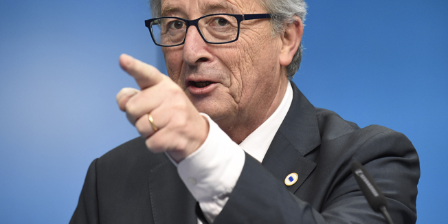 EU Commission President Jean Claude Juncker gives a joint press with European Council President Donald Tusk  and Italian Prime Minister Matteo Renzi (out of frame) following  the European Union summit at the EU headquarters in Brussels on December 18, 2014.    AFP PHOTO / JOHN THYS