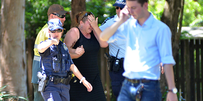 CORRECTION: CREDITPolice comfort a distressed woman at the scene where eight children aged between 18 months and 15 years were found dead at a home in the northern Australian city of Cairns, police said on December 19, 2014, reportedly after a gruesome mass stabbing.  A woman, 34, was injured in the incident in the suburb of Manoora, 10 minutes from the city centre. She is in a stable condition in hospital and assisting detectives with their inquiries, police said.  AFP PHOTO/COURTESY OF ABC FAR NORTH /ISAAC EGAN   ----EDITORS NOTE ----RESTRICTED TO EDITORIAL USE MANDATORY CREDIT 