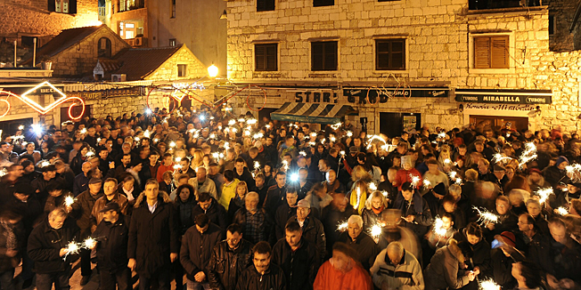 Omis,  201214.Na inicijativu udruge Volim Omis gradjani su na ulicama Omisa i trgu Stjepana Radica prosvjedovali zbog zanemarivanja grada od strane drzavnih institucija.Na fotografiji: Omisani su na trgu Stjepana Radica nakon drzavne himne i minute sutnje za poginule u Domovinskom ratu zapalili prskalice.Foto: Nikola Vilic  / CROPIX