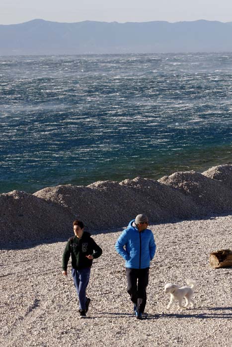 Makarska, 211214.Jaka bura je zapuhala na makarskom podrucju za prvi dan kalendarske zime. U 11 sati su izmjereni udari vjetra od 105km/h sto je dovelo do prekida trajektnog prometa na liniji Makarska-Sumartin (o.Brac). Takodjer je izmjerena i temperatura od 14 C, sto je neuobicajeno za ovo doba godine.Na fotografiji : Bura u Makarskoj.Foto: Ivo Ravlic / CROPIX