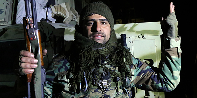 An Iraqi Kurdish Peshmerga fighter celebrates upon their arrival in Sinjar, west of the northern Iraqi city of Mosul on December 20, 2014 after an operation which broke the second Islamic State jihadist group (IS) siege of Mount Sinjar this year. The operation threatens the links between the city of Mosul, the main IS stronghold in Iraq, and territory the militant group controls in neighbouring Syria.  AFP PHOTO / SAFIN HAMED