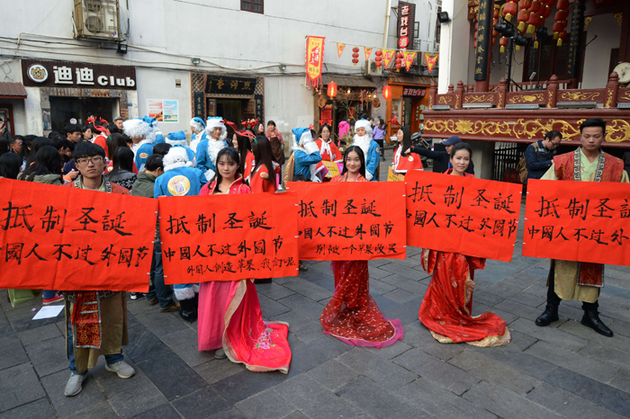 This picture taken on December 24, 2014 shows university students wearing traditional Chinese outfits holding banners reading 