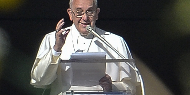 Pope Francis delivers a speech from the window of his apartment during his Angelus prayer in St Peter's Square at the Vatican on December 26, 2014.   AFP PHOTO / ANDREAS SOLARO