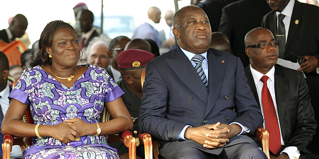(FILES) -- A file photo taken on February 4, 2011 shows then Ivory Coast's strongman Laurent Gbagbo (R) and his wife Simone attending a ceremony, in Abidjan, to pay tribute to thirty-two members of the National Armed Forces of Ivory Coast (FANCI) that lost their lives during the post-electoral violence, spawned by the November 28, 2010 presidential elections. Former first lady Simone Gbagbo is to go on trial in Abidjan on December 26, 2014 for her role in deadly post-election violence of 2010-2011.     AFP PHOTO/ SIA KAMBOU