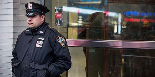 NEW YORK, NY - DECEMBER 22: A police officer stands guard outside a New York Police Department (NYPD) substation in Times Square on December 22, 2014 in New York City. Police officers are on high alert after NYPD officers, Wenjian Liu and Rafael Ramos, of the 84th Precinct were killed execution style on December 20 as they sat in their marked police car on a Brooklyn street corner.   Andrew Burton/Getty Images/AFP== FOR NEWSPAPERS, INTERNET, TELCOS & TELEVISION USE ONLY ==