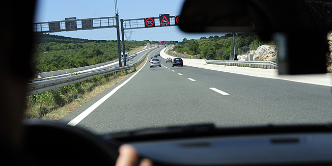 Dugopolje,  170810.Prometni policajci Kristian Perisic i Tonci Pivic iz postaje Prometne policije Split svakodnevno nadziru promet na autoputu A1 od Dugopolja do Sibenika.Nadzor vrse pomocu vrlo brzog BMW automobila kojim presrecu vozace koji voze prebrzo pri cemu ih snimaju kamerom i naplacuju kaznu od 500 do nekoliko tisuca kuna ovisno o brzini.Na fotografiji policajci prate i snimaju vozilo koje vozi prebrzo.Foto: Nikola Vilic / CROPIX