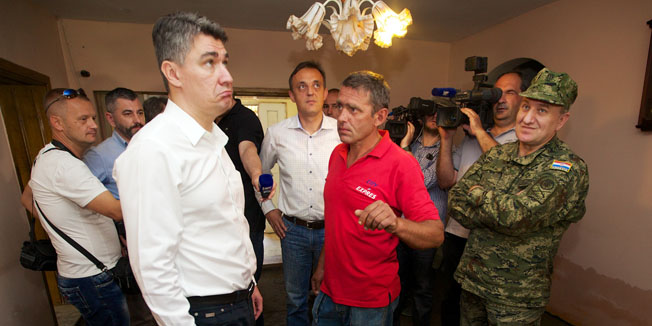 Rajevo Selo, Gunja, 010714.Predsjednik Vlade Zoran Milanovic posjetio je podrucje pogodjeno poplavama.U Rajevom Selu je obisao nasip i posjetio obitelj Andric a u Gunji je posjetitio javnu kuhinju,gradiliste novog objekta Udruge Zvjezdica,te lokaciju na kojoj pocinje gradnja privremenog kontejnerskog naselja.Na fotografiji: premijer Milanovic kod obitelji Andric u Rajevom SeluFoto: Vlado Kos / Cropix