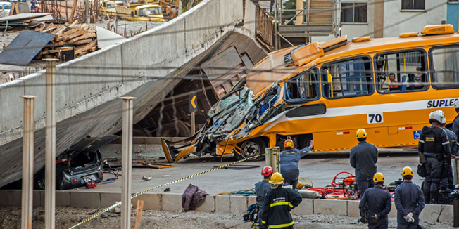 Firefighters and policemen work at the site where several vehicles were crushed by a viaduct that collapsed in Belo Horizonte, Brazil, on July 3, 2014. An unfinished overpass collapsed on vehicles in Brazil's southeastern World Cup city of Belo Horizonte on Thursday, killing at least two people and injuring 19, officials said. AFP PHOTO/PEDRO DUARTE