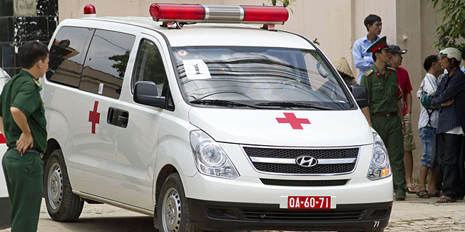 Soldiers stand next to an ambulance at the entrance of Hospital 105 where the victims of a helicopter crash were brought in Hanoi on July 7, 2014. Sixteen people were killed and five injured when a Vietnamese military helicopter crashed in the capital Hanoi earlier in the day, a top military official said.        AFP PHOTO