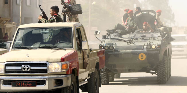 Security forces patrol a street in the city of Benghazi on June 25, 2014 as Libyans vote in a parliamentary election. Libyans are voting in a parliamentary election the authorities hope will end political turmoil and deadly violence that has gripped the country since the ouster of dictator Moamer Kadhafi. AFP PHOTO / ABDELLAH DOMA