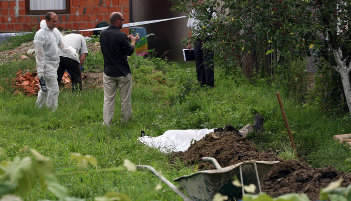 Drenovci, 170610.Muskarac star 50 godina ubijen je u cetvrtak ujutro u dvoristu kuce u Nazorovoj ulici 108 u Drenovcima, selu u okolici Zupanje. Ubijen je s vise hitaca iz automatskog oruzja. Smrtnosne hice u 50-godisnjaka ispalio je njegov 60-godisnji sumjestanin, i susjed. Ubojstvo se dogodilo oko 8 sati, a prema nesluzbenim saznanjima, hicima iz vatrenog oruzja prethodio je verbalni sukob dvojice muskaraca. Na fotografiji ocevidna ekipa PU vukovarsko-srijemske, utvrdjuje se okolnosti koje su dovele do ubojstva. Tijelo ubijenog.Foto: Damir Glibusic / CROPIX