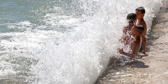 Split, 080714.Nekima juzina donosi glavobolju a nekima radost. Mladi splicani uzivaju u valovima sto ih je donijela juzina na splitsku plazu Firule. Foto: Marijo Basic  / CROPIX