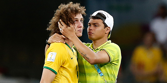 TOPSHOTSBrazil's defender Thiago Silva (R) conforts Brazil's defender David Luiz after the semi-final football match between Brazil and Germany at The Mineirao Stadium in Belo Horizonte during the 2014 FIFA World Cup on July 8, 2014.   AFP PHOTO / ADRIAN DENNIS
