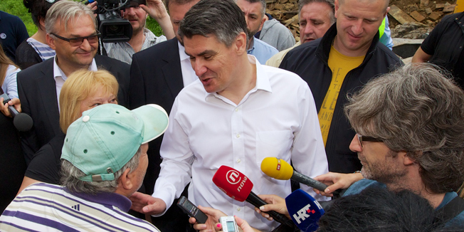 Gunja, Rajevo Selo, 090714.Predsjednik Vlade Republike Hrvatske Zoran Milanovic posjetio je Gunju, Rajevo Selo i Drenovce. Premijer je zajedno s ministricom graditeljstva i prostornog uredjenja Ankom Mrak-Taritas obisao kuce na kojima su poceli gradjevinski radovi u sklopu Vladinog programa obnove poplavom stradalih podrucja.Na fotografiji: ministrica Anka Mrak Taritas i premijer Zoran Milanovic u Rajevom Selu gdje se radi na obnovi kuca..Foto: Vlado Kos / Cropix