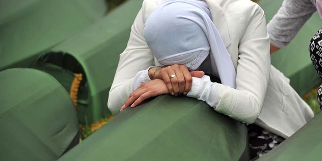 A Bosnian Muslim woman, survivor of the Srebrenica 1995 massacre cries by the coffin of a relative, layed out among others at the memorial cemetery in the village of Potocari near the eastern-Bosnian town of Srebrenica, on July 11, 2014. Several thousand people gathered on July 11 in Srebrenica for the 19th anniversary of the massacre of some 8,000 Muslim males by ethnic Serbs forces, Europe's worst atrocity since World War II. A total of 175 newly-identified massacre victims will be laid to rest after a commemoration ceremony held in Potocari, just outside the ill-fated Bosnian town. AFP PHOTO / ELVIS BARUKCIC