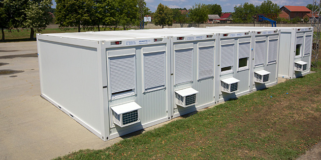 Gunja, 030714.Na skolskom igralistu u Gunji zapocelo je postavljanje kontejnerskog naselja za ljude cije su kuce srusene ili se trebaju srusiti.Postavit ce se 30 kontejnera sa strujom i vodom i klimom,dva kontejnera za pranje rublja i jedan kontejner za osobnu higijenu.Na fotografiji: pet prvih kontejnera za stanovanje koji su dovezeni rano jutos.Foto: Vlado Kos / Cropix
