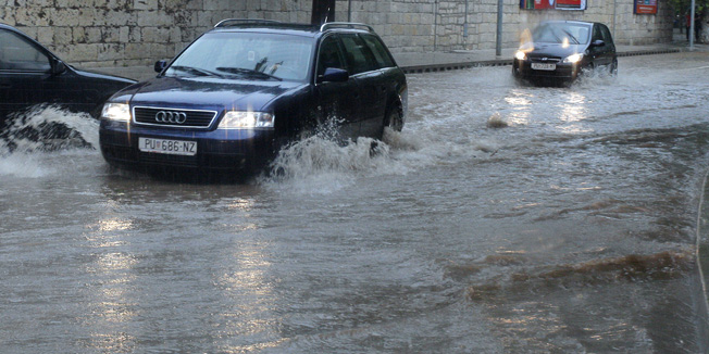 Pula, 140714.Od ponoci do 10 sati ujutro u Puli je palo 74 litre kise po cetvornom metru.Jake oborine uz grmljavinu zadavale su probleme u prometu. Radnici Komunalca otvaraju i ciste poklopce sahtova kako bi voda mogla lakse otjecati.Foto: Goran Sebelic / CROPIX                              