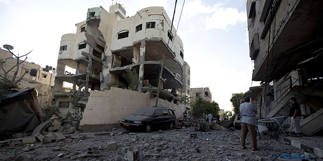 CORRECTING BYLINE Palestinians stand next to the house of senior Hamas official Mahmud al-Zahar after it was destroyed by an overnight Israeli air strike, on July 16, 2014, in Gaza City. New Israeli air and tank strikes in Gaza early today killed several people, medics said, bringing the death toll from Israel's operation in the besieged Palestinian territory to 204. AFP PHOTO / MAHMUD HAMS