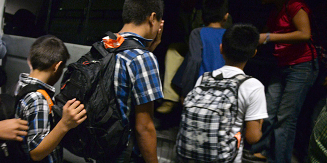 Part of a group of 16 Guatemalan children caught in Mexico while trying to migrate illegally into the United States, climb into a minibus at Aurora international airport in Guatemala City on July 14, 2014 upon their arrival after being deported from Mexico. US authorities have detained some 57,000 unaccompanied minors since October, twice the number from the same period a year ago, seeking to illegally cross into the US from Mexico. Three quarters of the minors are from El Salvador, Guatemala and Honduras.  AFP PHOTO / Johan ORDONEZ