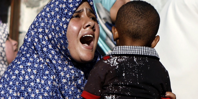 CORRECTS NAME OF PHOTOGRAPHER IN BODY OF THE CAPTION-Relatives of four boys, all from the Bakr family, mourn during their funeral in Gaza City, on July 16, 2014. Four children were killed and several injured at a beach in Gaza City medics said, in Israeli shelling witnessed by AFP journalists. The strikes appeared to be the result of shelling by the Israeli navy against an area with small shacks used by fishermen. The deaths raised the overall toll in nine days of violence in Gaza to 213. AFP PHOTO / MOHAMMED ABED