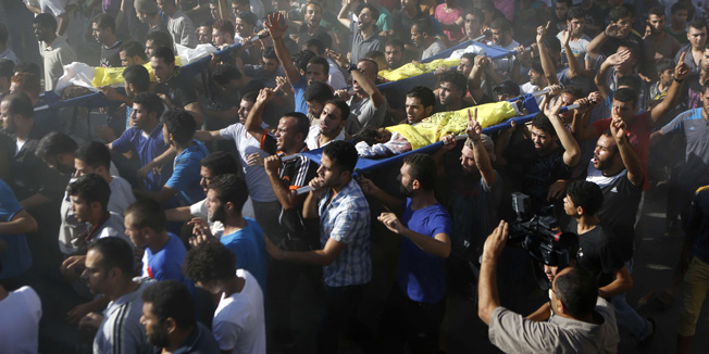 TOPSHOTSPalestinian mourners shout slogans during the funeral of four boys, all from the Bakr family, in Gaza City, on July 16, 2014. Four children were killed and several injured at a beach in Gaza City medics said, in Israeli shelling witnessed by AFP journalists. The strikes appeared to be the result of shelling by the Israeli navy against an area with small shacks used by fishermen. The deaths raised the overall toll in nine days of violence in Gaza to 213. AFP PHOTO/MOHAMMED ABED
