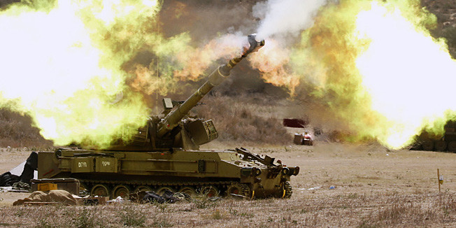 TOPSHOTSAn Israeli army US made self-propelled howitzer 155m  cannon fires a shell from the Israel-Gaza border into the Gaza Strip on July 18, 2014. Israeli Prime Minister Benjamin Netanyahu said today he had ordered the military to prepare for a possible significant expansion of the ground operation against Gaza militants.  AFP PHOTO / JACK GUEZ