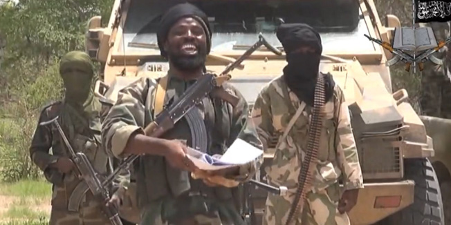 A screengrab taken on July 13, 2014 from a video released by the Nigerian Islamist extremist group Boko Haram and obtained by AFP shows the leader of the Nigerian Islamist extremist group Boko Haram, Abubakar Shekau (C). The head of Nigeria's Boko Haram Islamists, Abubakar Shekau, has voiced support for the extremist Sunni Islamic State (IS) militant group, which has taken over large swathes of Iraq and Syria, in a new video seen on July 13. AFP PHOTO / BOKO HARAMRESTRICTED TO EDITORIAL USE - MANDATORY CREDIT 