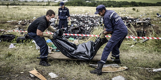 TOPSHOTSUkrainian State Emergency Service employees collect bodies of victims at the site of the crash of a Malaysia Airlines plane in Grabove, in rebel-held east Ukraine on July 20, 2014. The missile system used to shoot down a Malaysian airliner was handed to pro-Russian separatists in Ukraine by Moscow, the top US diplomat said Sunday. Outraged world leaders have demanded Russia's immediate cooperation in a prompt and independent probe into the shooting down on July 17 of flight MH17 with 298 people on board. AFP PHOTO/ BULENT KILIC