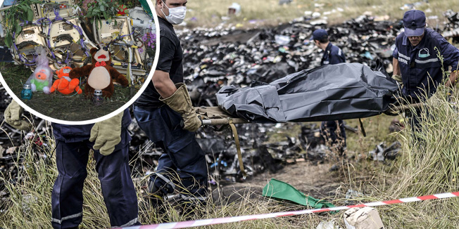 Ukrainian State Emergency Service employees collect bodies of victims at the site of the crash of a Malaysia Airlines plane in Grabove, in rebel-held east Ukraine on July 20, 2014. The missile system used to shoot down a Malaysian airliner was handed to pro-Russian separatists in Ukraine by Moscow, the top US diplomat said Sunday. Outraged world leaders have demanded Russia's immediate cooperation in a prompt and independent probe into the shooting down on July 17 of flight MH17 with 298 people on board. AFP PHOTO/ BULENT KILIC