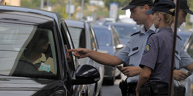 Buje, 240713.Od ulaska Hrvatske u EU na granicnom prijelazu Kastel-Dragonja na snazi je tzv. one stop rezim kontrole granica. Hrvatsko-slovenska policija zajedno kontrolira  dokumente tako da je protocnost putnika puno veca. Unatoc tome za vrijeme ljeta kolone vozila ipak su nezaobilazna stvar.Foto: Goran Sebelic / CROPIX