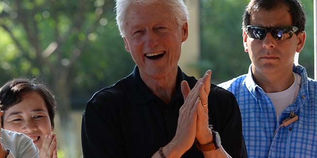 Visiting former US president Bill Clinton (C) claps as he watches  children dancing during a visit at an orphanage with HIV-infected kids in the outskirts of Hanoi on July 18, 2014. Clinton is making a one-day visit to Hanoi, part of his Asian tour that includes India, Indonesia, Papua New Guinea and Australia. AFP PHOTO/HOANG DINH Nam