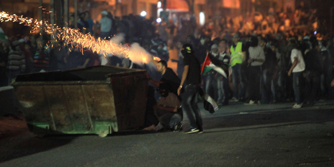 At least 10,000 Palestinian protesters marching against Israel's military offensive in the Gaza Strip clash with Israeli soldiers and border police at the Israeli Qalandiya checkpoint, between Jerusalem and Ramallah, on 25 July 2014. Israeli security forces shot dead a Palestinian man and wounded 150 other people during the massive protest in the West Bank in support of fellow Palestinians in the Gaza Strip. The confrontation, and several smaller skirmishes throughout Israeli-annexed east Jerusalem, came on Laylat al-Qadr, or Night of Destiny, when Muslims pray through the night as the holy month of Ramadan nears its end. AFP PHOTO/ABBAS MOMANI