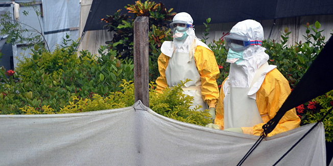Members of Doctors Without Borders (MSF) wearing protective gear walk outside the isolation ward of the Donka Hospital, on July 23, 2014 in Conakry. A Liberian man has been hospitalised in Lagos with Ebola-like symptoms, but it is not yet clear if he is infected with the killer virus, Nigerian officials said on July 24. Ebola first emerged in 1976 in what is now the Democratic Republic of Congo, and is named after a river in that country. AFP PHOTO / CELLOU BINANI
