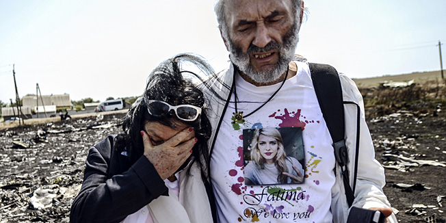 TOPSHOTSJerzy Dyczynsk (R) and Angela Rudhart-Dyczynski from Australia react as they arrive on July 26, 2014 at the crash site of the Malaysia Airlines Flight MH17 to look for their late daughter Fatima, near the village of Hrabove (Grabovo), in the Donetsk region. Ukraine sought on July 25 to avoid a political crisis after the shock resignation of its prime minister, as fighting between the army and rebels close to the Malaysian airliner crash site claimed over a dozen more lives. Dutch and Australian forces were being readied on July 26 for possible deployment to secure the rebel-held crash site of the Malaysia Airlines flight MH17 in east Ukraine where many victims' remains still lie nine days after the disaster claimed 298 lives. AFP PHOTO/ BULENT KILIC