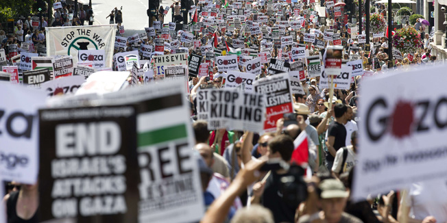 TOPSHOTSDemonstrators march through the streets from outside the Israeli embassy in central London on July 26, 2014, calling for an end to violence in Gaza. At least 10,000 pro-Palestinian protesters opposed to Israel's military action in Gaza marched through central London for the second week running on Saturday. Demonstrators held placards reading 