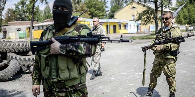 Pro-Russia separatists stand at their checkpoint near the front line in the northern outskirts of city of Donetsk, on July 22, 2014. Terrified civilians fled as intense clashes yesterday between Ukrainian government troops and pro-Russian rebels left at least four people dead on the outskirts of the insurgent bastion of Donetsk. A military spokesman said yesterday government troops were battling back control of the districts around the airport and had broken through the rebel cordon to reach their comrades inside.  AFP PHOTO/ BULENT KILIC