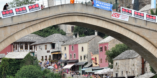 A man jumps from the Stari Most bridge over the river Neretva in Mostar during the 448th traditional high diving competition on July 27, 2014. The Stari Most is an Ottoman era structure, 4 meters wide and 30 meters long, that dominates the riverside scenery from height of 24 meters, built in 16th century. 