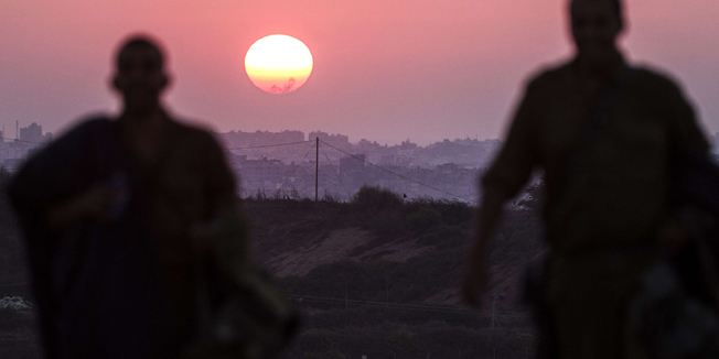 A picture taken from the Israeli border with the Gaza Strip shows the sun setting over the Palestinian coastal enclave on August 4, 2014. Israel insisted there will be no end to its bloody military campaign in Gaza without achieving long-term security for its people, shunning increasingly vocal world demands for a truce. AFP PHOTO / JACK GUEZ