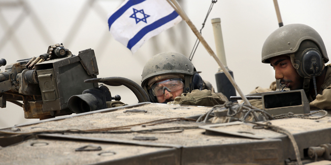 Israeli soldiers manoeuvre their Merkava tank near the border between Israel and the Gaza Strip as they return from the Hamas-controlled Palestinian coastal enclave on August 5, 2014, after Israel announced that all of its troops had withdrawn from Gaza. Israel completed the withdrawal of all troops from Gaza as a 72-hour humanitarian truce went into effect following intense global pressure to end the bloody conflict. AFP PHOTO / THOMAS COEX