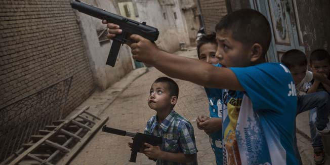 KASHGAR, CHINA - JULY 29:  Uyghur boys play with toy guns on the Eid holiday on July 29, 2014 in alleyway in old Kashgar, Xinjiang Province, China. Nearly 100 people have been killed in unrest in the restive Xinjiang Province in the last week in what authorities say is terrorism but advocacy groups claim is a result of a government crackdown to silence opposition to its policies. China's Muslim Uyghur ethnic group faces cultural and religious restrictions by the Chinese government. Beijing says it is investing heavily in the Xinjiang region but Uyghurs are increasingly dissatisfied with the influx of Han Chinese and uneven economic development.  (Photo by Kevin Frayer/Getty Images)
