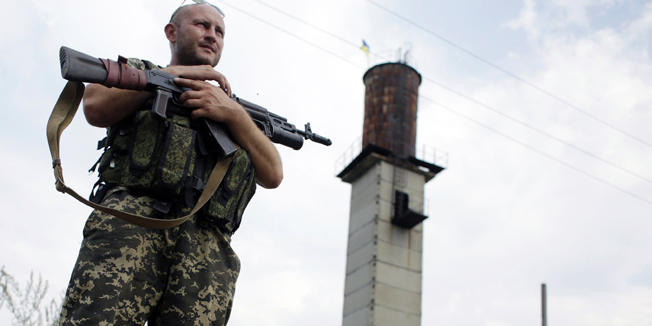 A Ukrainian soldier stands guard at a check-point near the eastern Ukrainian city of Donetsk on August 11, 2014. Ukrainian troops have moved in on Donetsk, the largest city in eastern Ukraine, pounding neighbourhoods with shelling in an attempt to drive out pro-Russian separatists. Over 1,300 have been killed and more than 285,000 people have fled their homes in the east due to fierce clashes in four months of what the Red Cross has already deemed a civil war. AFP PHOTO/ ANATOLII STEPANOV