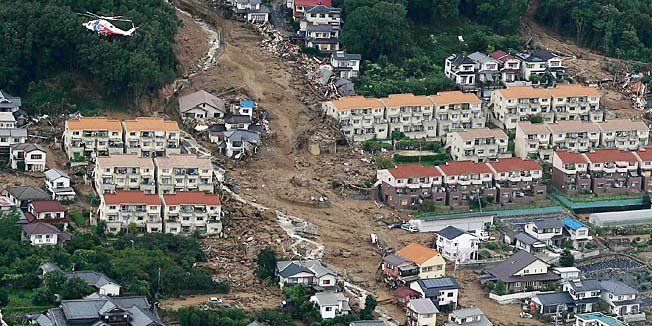 This aerial view shows the damage caused by a landslide after heavy rains hit the city of Hiroshima, western Japan, on August 20, 2014. At least 18 people were killed and another 13 were still missing after a huge landslide engulfed homes in western Japan, reports said on August 20.      JAPAN OUT       AFP PHOTO / Jiji Press